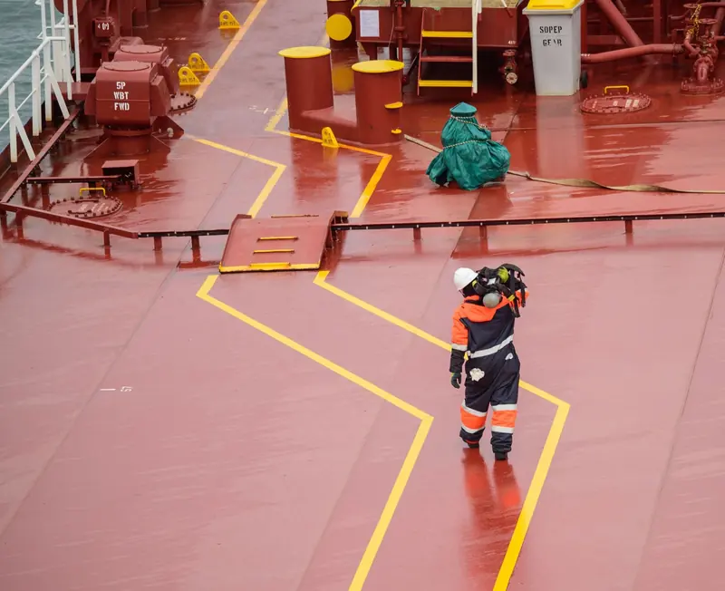 Seafarer walking across the deck of a tanker